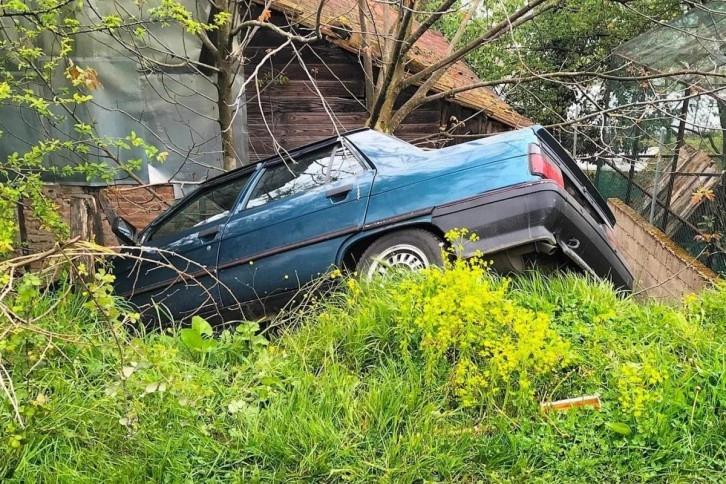 Açılan kapıyı kapatmak isterken otomobili evin bahçesine devrildi