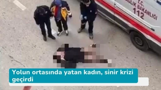 Yolun ortasında yatan kadın, sinir krizi geçirdi